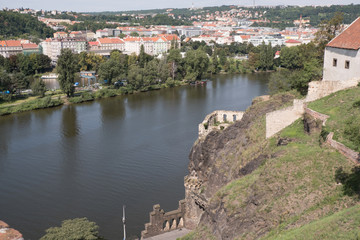 Fototapeta na wymiar View of Prague and the Vltava River from Vysehrad Fortress. Looking across the Vltava River and a European town.