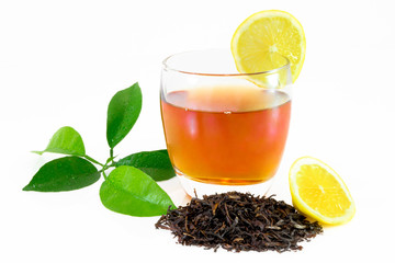 Dry black tea leaves, lemon leafs, tea on glass isolated on white