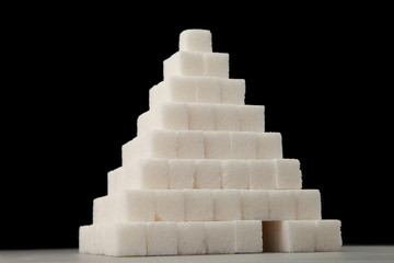 Pyramid of sugar cubes/ Pyramid of sugar cubes, isolated on a black background