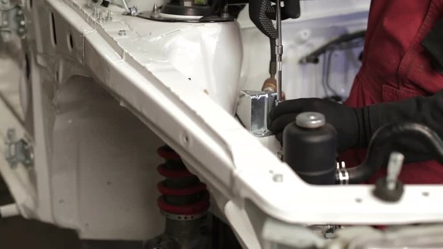 The mechanic works on rebuilding of sport rally car.