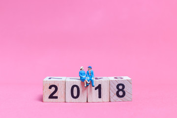 Couple sitting on wooden block number 2018