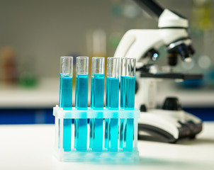 Chemical lab, test tubes and microscope on foreground