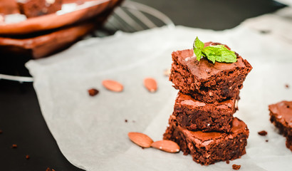 pyramid of freshly prepared home fresh brownies with nuts and figs, on a black background
