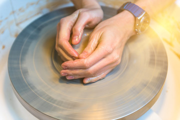 womens hands of a potter creating an earthen jar