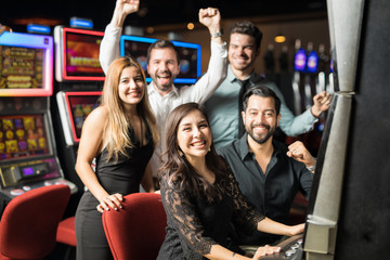 Fototapeta premium Group of friends playing slots in a casino
