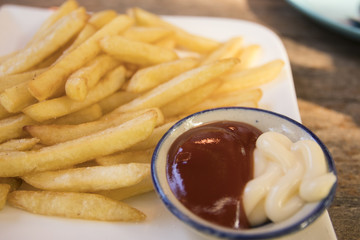 Close up french fries on disk with tomato and mayonnaise sauce
