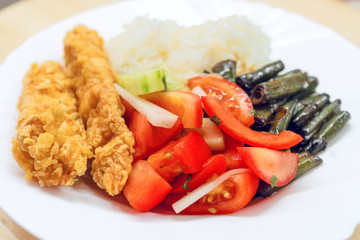 Plate with food. Rice, tamates, meat and beans.