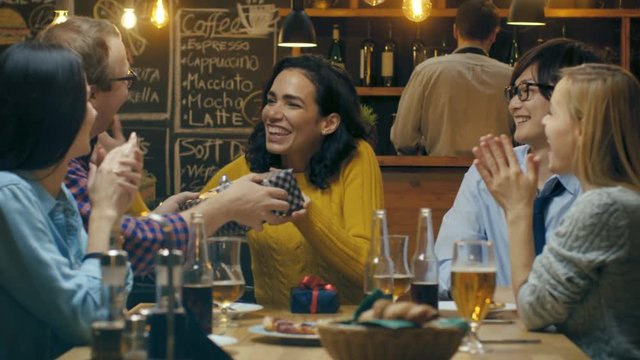 In the Bar/ Restaurant Beautiful Hispanic Woman Receives Gifts and Congratulations From Her Best Friends. Everybody is Happy! Shot on RED EPIC-W 8K Helium Cinema Camera.