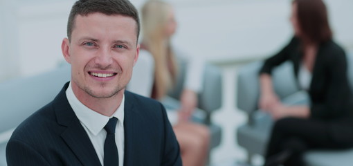 Portrait of a smiling business man with colleagues working in th