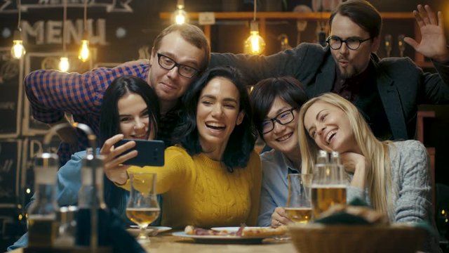 In the Bar/ Restaurant Hispanic Woman Takes Selfie of Herself and Her Best Friends. Group Beautiful Young People in Stylish Establishment.  Shot on RED EPIC-W 8K Helium Cinema Camera.