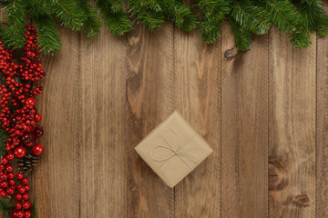 Fototapeta na wymiar Caja de regalos sobre fondo de madera y guirnalda verde y roja
