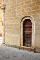 Fototapeta na wymiar Porta antica in palazzo storico, nel centro di Pienza, Toscana, Italia