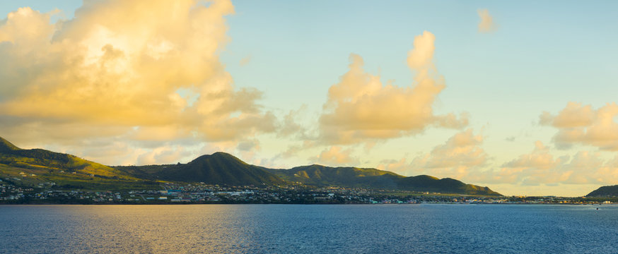 Panoramic view of St Kitts from the sea during golden hour at dawn.
