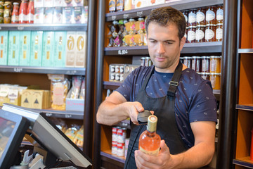 Checkout clerk scanning bottle of wine
