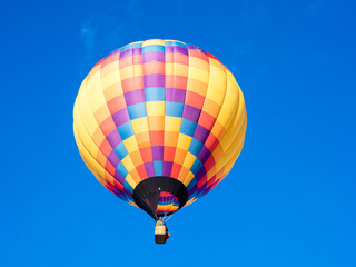 Colorful hot air balloon flying in the bright blue sky during Winthrop Balloon Festival in Washington state