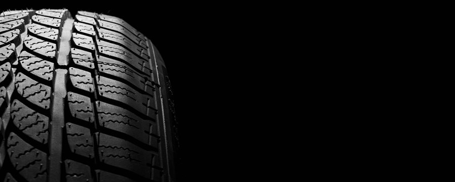 car winter tyre on black  background. vehicle wheel pneumatic