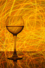 a glass of white wine on a blurred colored background
