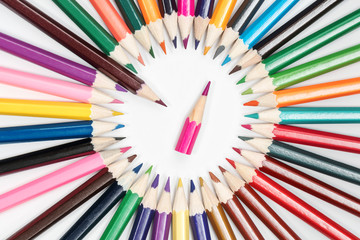 Circle of pencils with a little pencil in the center on a white paper