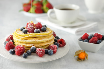 Homemade pancakes with berries and a cup of coffee.