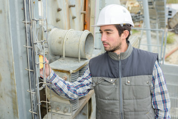 industrial worker looking at tag on outdoor equipment