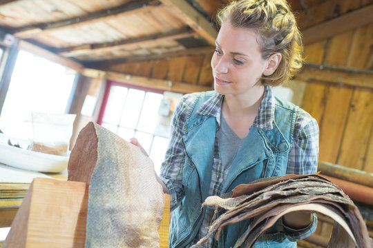 craftswoman inspecting snake skin in her workshop