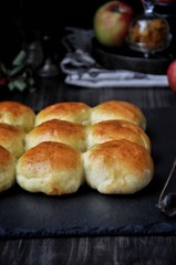 Buns of yeast dough stuffed with apples and raisins. Dark background, fresh apples