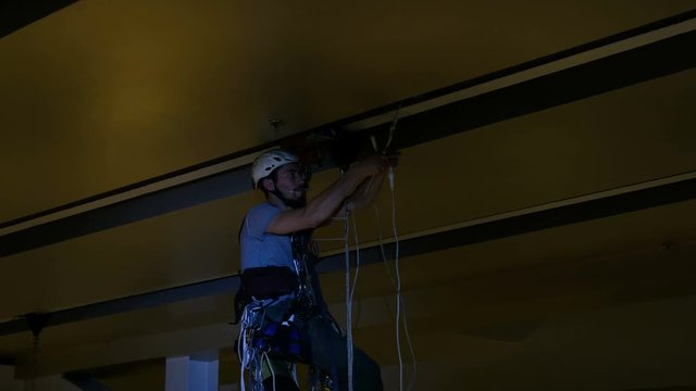 Industrial climber mounts Christmas decorations in the unsupported space in the shopping center