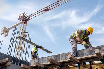 Worker At The Construction Site Is Fixing Forms For The Beams.