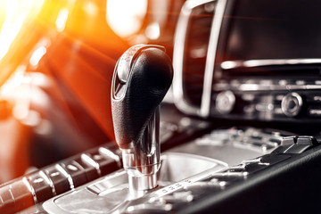 Close-up on automatic transmission lever in modern car. multimedia and navigation control buttons. Car interior details. Transmission shift.