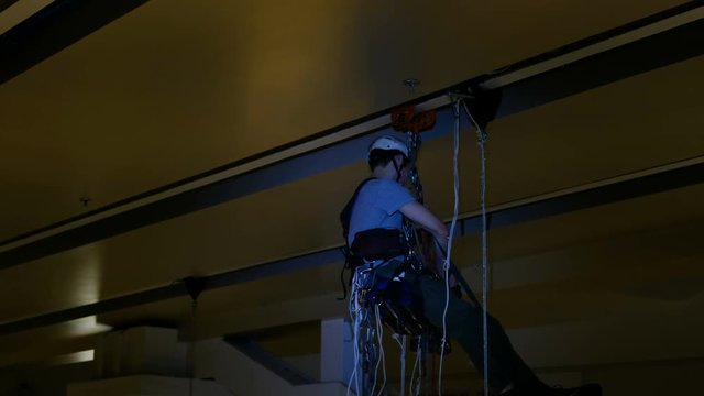 Industrial climber mounts Christmas decorations in the unsupported space in the shopping center