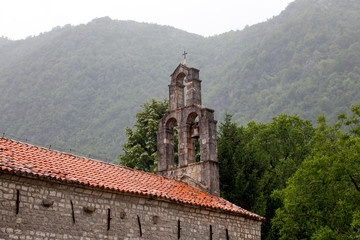 Fototapeta premium Old monastery with orange roof in front of mountains