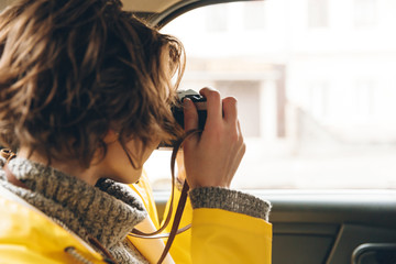 Pretty young lady photographer dressed in raincoat