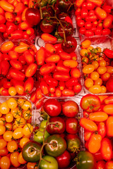 Variety of tomatoes for sale at a grocers shop.