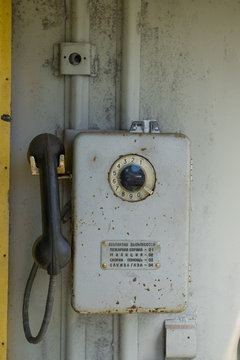 Grey Antique Soviet Phone Hanging on Wall Outside
