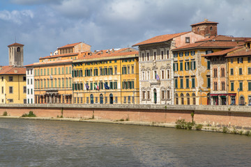 Fototapeta na wymiar Bright italian houses on the Arno river in Pisa, Tuscany, Italy.