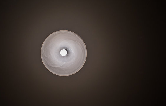 Chandelier with a black shade of a lamp under a stretch ceiling - a view from below.