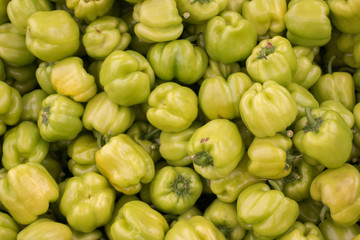 Fresh Green Bell Peppers Heap on Market Stall For Sale