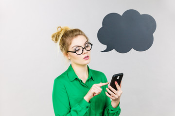 Focused business woman looking at phone, thinking bubble
