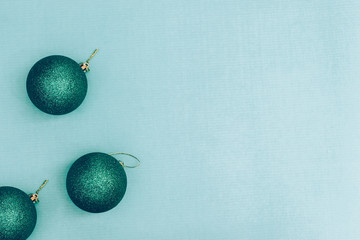 Green shiny Christmas balls on a blue background