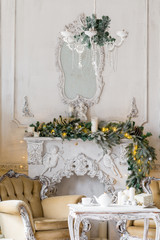 Christmas morning . classic apartments with a white fireplace, decorated fir tree, sofa, large windows and chandelier.