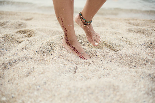 Woman legs on sea shore