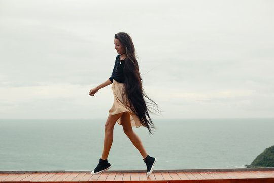 Young female with very long hair have fun and enjoy on sea shore