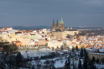 Obraz premium Zamek na Hradczanach i ośnieżone dachy Małej Strany z Seminarska Garden w Pradze, Czechy