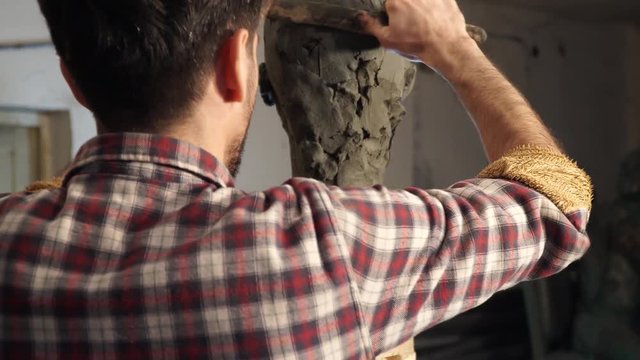 sculptor working female bust from pottery clay