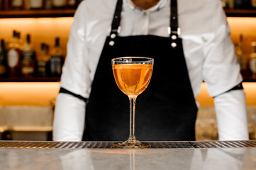 A glass filled with a golden alcholic drink