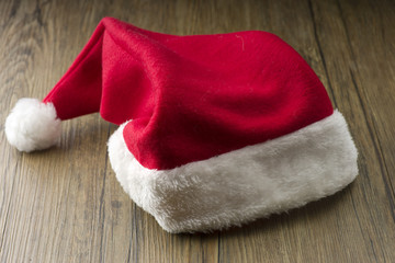 Obraz na płótnie Canvas Santa Claus red hat on the wood background.