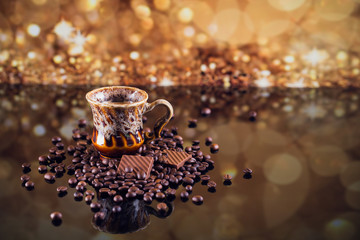 Cup of coffee on heap of roasted coffee beans.