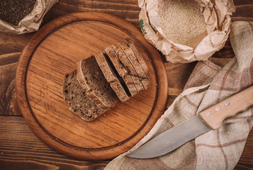 Many mixed baked breads and rolls on rustic wooden table