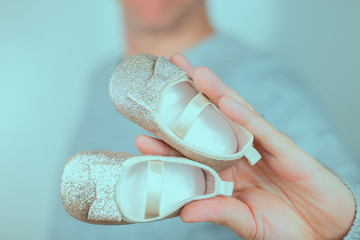 Goldene Babyschuhe für Mädchen in Hand