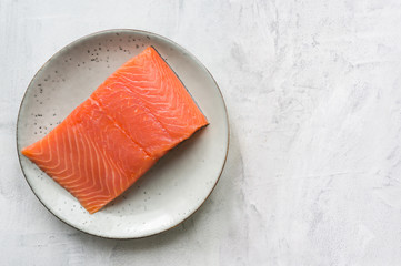 Fresh salmon steak on rustic plate. Top view.